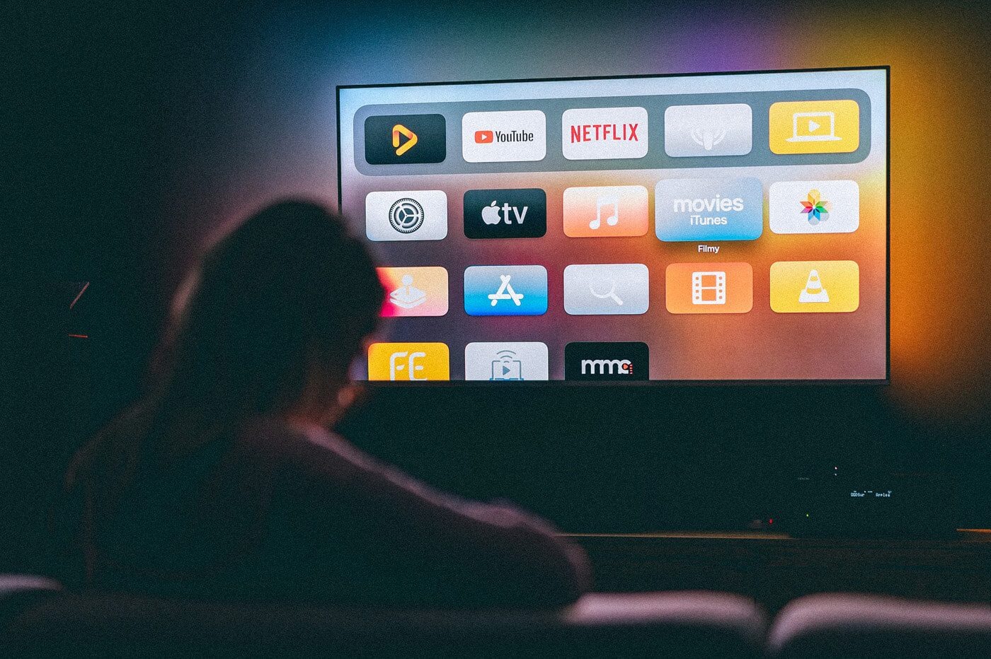 Smart TV interface displaying popular streaming apps including YouTube, Netflix, Apple TV, and other entertainment services